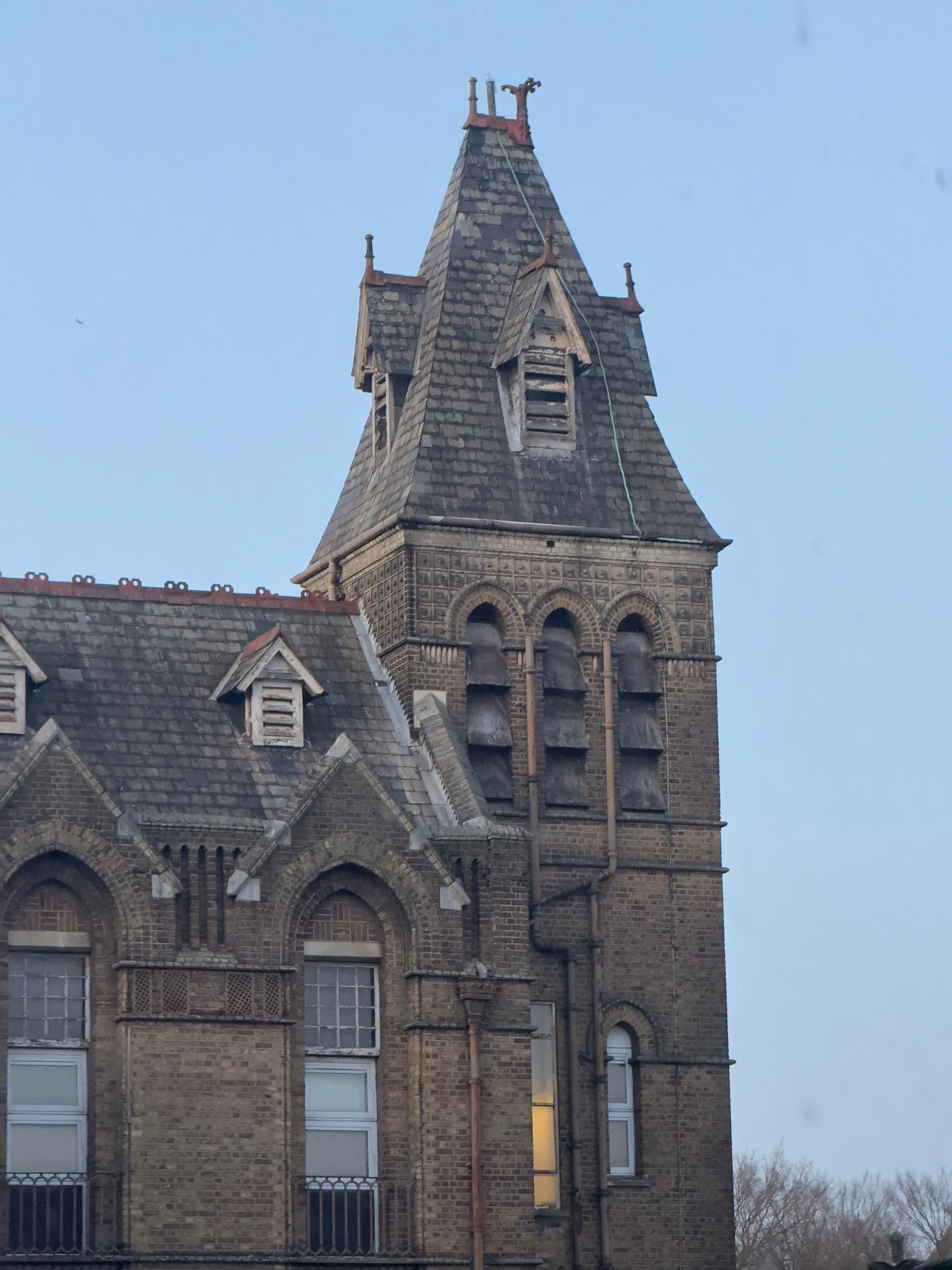 The disused Victorian infirmary and Nightingale wards of the former Archway Wing — abandoned medical apparatus, peeling institutional corridors, and gothic towers above Highgate Hill.